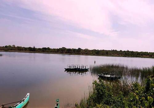 three boats sitting on the water in a lake at Ganesh Gate in Pottuvil