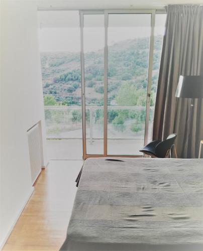 a bedroom with a bed and a large window at Casa de ls Cristales in Bemposta