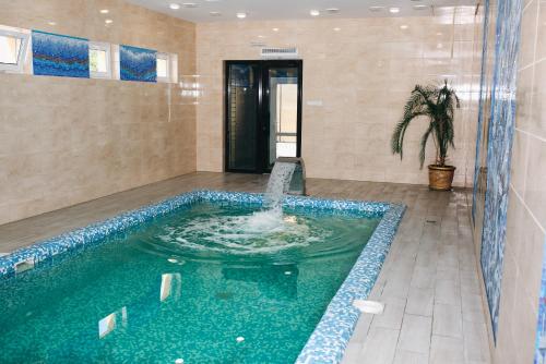 a swimming pool with a fountain in a room at ОРК "Блісс" in Rivne