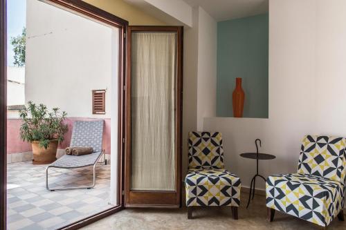 a living room with two chairs and a glass door at Palau Sa Font in Palma de Mallorca
