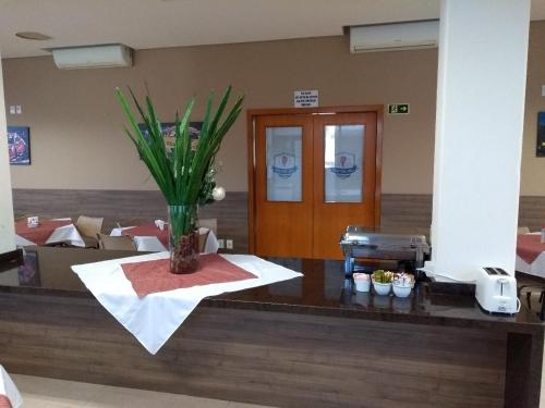 a restaurant with a counter with a plant on it at Hotel Ville House Premium in Canoas