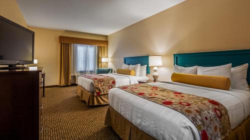 a hotel room with two beds and a flat screen tv at Best Western Plus Dayton in Dayton