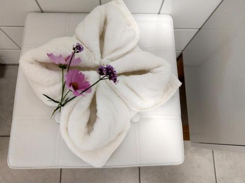 a white towel with flowers on a white bench at Panorama-Übernachtungen in Ummendorf-Biberach