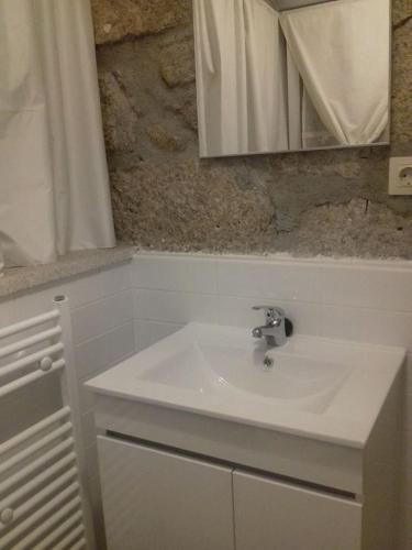 a bathroom with a white sink and a mirror at Casinha de Lamares in Vila Real