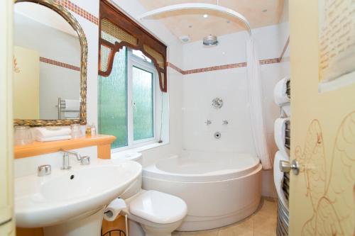 a bathroom with a tub and a sink and a toilet at Three Ways House Hotel in Chipping Campden