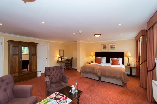 a bedroom with a bed and a living room at Three Ways House Hotel in Chipping Campden