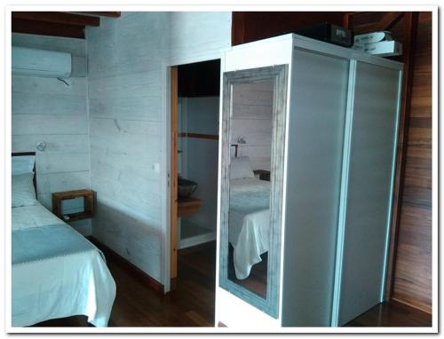 - une chambre avec un lit et une armoire en verre dans l'établissement Quenetier, à Saint-François