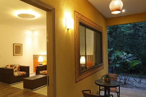 a hallway with a living room with a table and a mirror at Amazon Ecopark Jungle Lodge in Manaus