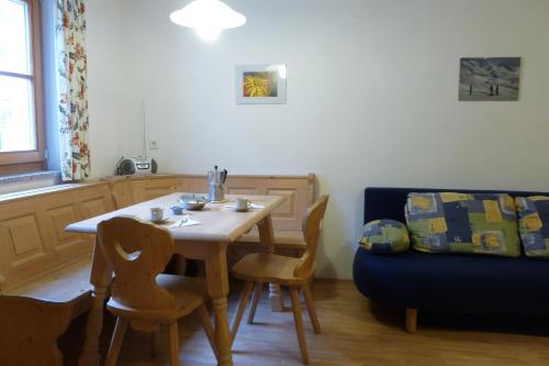 a dining room with a table and a blue couch at Ferienwohnungen Auhaus in Martello
