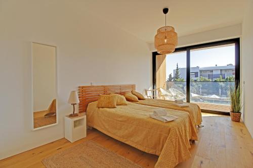 ヴィラモウラにあるWHITE & NATURE APARTMENTのベッドルーム(大型ベッド1台、大きな窓付)