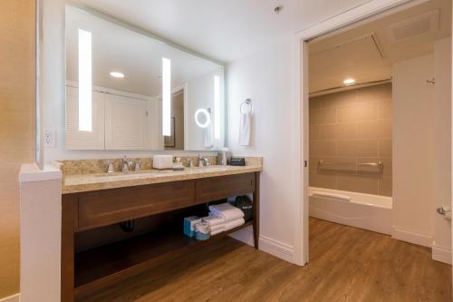 a bathroom with a sink and a large mirror at Carlsbad Seapointe Resort in Carlsbad