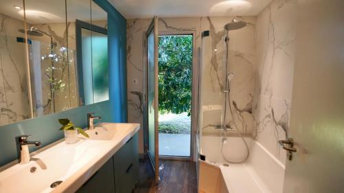 グリモーにあるGolfe de Saint Tropez- Beauvallon Villaのバスルーム(シンク2台、シャワー、バスタブ付)