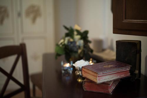 two stacks of books on a table with a vase of flowers at Convento San Bernardino in Montefranco