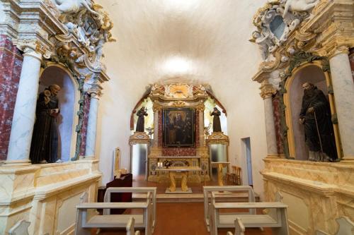 an altar in a church with statues on the walls at Convento San Bernardino in Montefranco