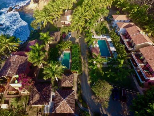an aerial view of a resort with palm trees and the ocean at Hotel Punta Franca in Jobal