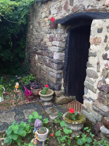 a stone building with potted plants in front of a door at Le Petit Chateau, Matisse in Noyal-Pontivy