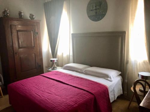 a bedroom with a large bed with a red blanket at A casa di V-Ale in Treviso
