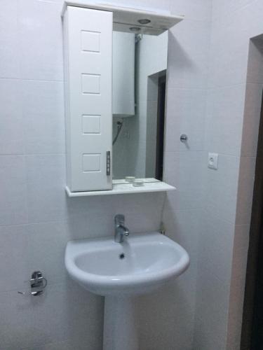a white bathroom with a sink and a mirror at Teona's Guesthouse in Mestia in Mestia