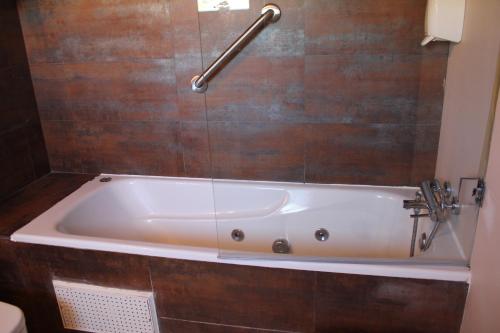 a bath tub in a bathroom with wooden tiles at Hospedería de Cuenca in Cuenca