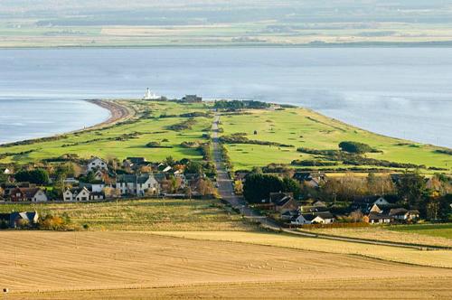 a small town on a hill next to the ocean at The Mended Drum in Fortrose