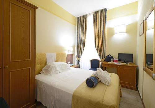 a hotel room with a bed and a desk at Hotel & Terme Bagni di Lucca in Bagni di Lucca