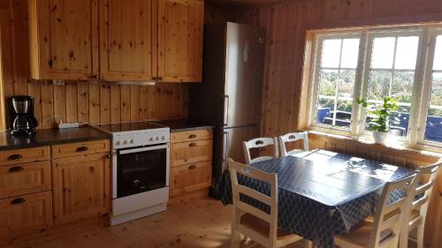 a kitchen with a table and a stove and a refrigerator at Vesterveien Panorama in Arendal