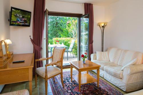 - un salon avec un canapé et une table dans l'établissement Hotel Al Fiume, à Tegna