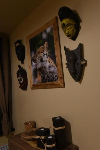 a wall with a picture of a cat and masks at Cheetah Holiday Club in Vizovice
