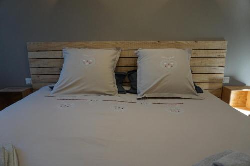 a white bed with two pillows on top of it at Chambres et table d’hôtes le Barret in Beauzac