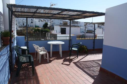 Un patio con sillas y una mesa en el balcón. en Casa Lomas, en Arcos de la Frontera