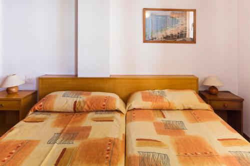 two beds sitting next to each other in a bedroom at Apartamentos Arlanza - Only Adults in Playa d'en Bossa