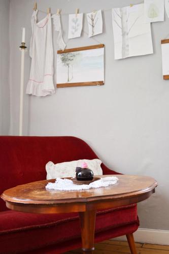 a table in a room with a red couch and a red chair at Sergel B&B Lindshammar in Lindshammar