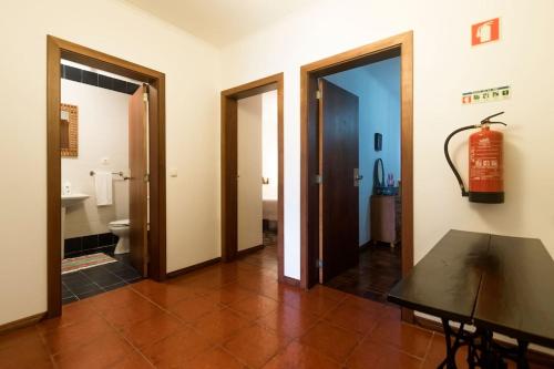 a hallway with two doors and a room with a toilet at Casa Caió in Ribeira Grande