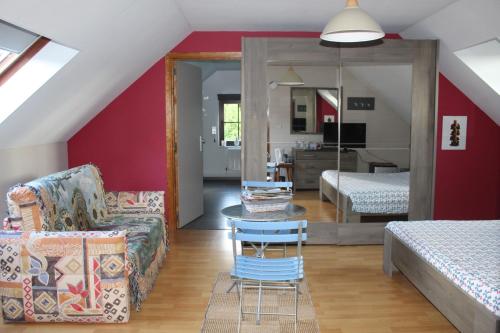 sala de estar con sofá, mesa y dormitorio en Chambre en Ardenne, en Graide