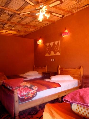 a bedroom with two beds and a ceiling at Maison d'Hôte Valentine in Tinerhir