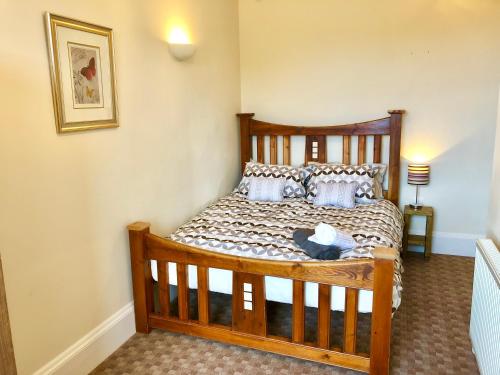 a bedroom with a wooden bed with pillows at Carr View Hall Apt3 Grade II Listed in Sleights
