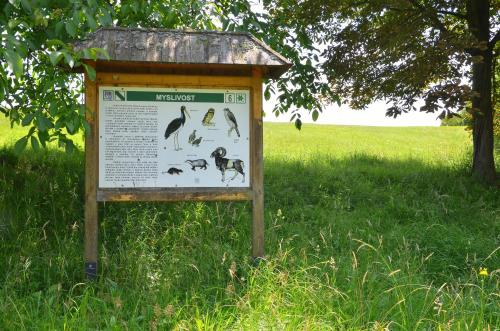 a sign in the grass next to a field at Chalupa Bohunka in Bouzov