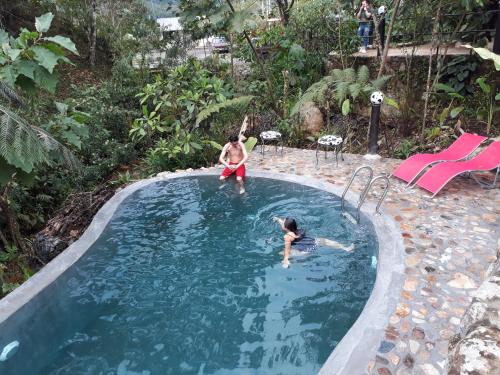 two people are playing in a swimming pool at Finca de la Vaca - Family House in Mera