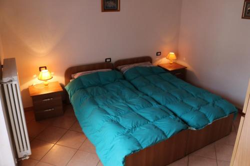 a bedroom with a bed with a blue blanket on it at Casa al Lago Trentuno B in Zenna