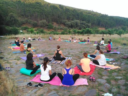 a group of people sitting in the water doing yoga at Akassa Alojamientos Bioclimaticos en las Hurdes in Pinofranqueado