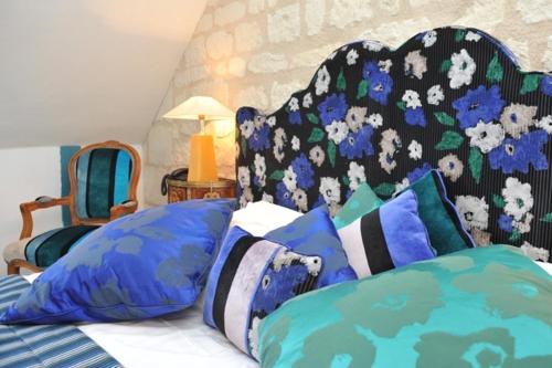 a bedroom with a bed with blue and white pillows at Logis Demeure de la Vignole in Turquant
