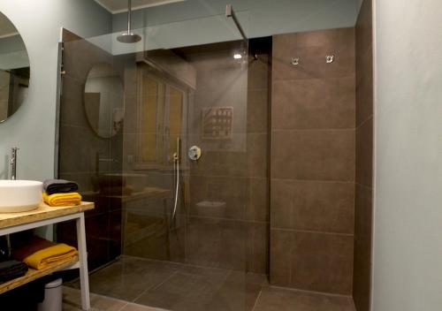 W łazience znajduje się prysznic ze szklanymi drzwiami. w obiekcie il gabbiano giallo w mieście Fano