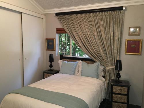 een slaapkamer met een bed en een raam bij 7 Badger Street in Johannesburg