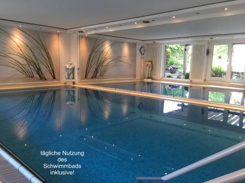 a swimming pool in a house with an indoor swimming pool at Appartementresidenz am Kurpark - Ferienwohnungen mit Pool & Sauna & Garage in Bad Salzuflen
