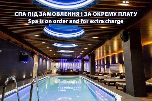 a hot tub in a hotel with a sign that reads spa on order and for at Park Hotel Warshawskiy in Sarny