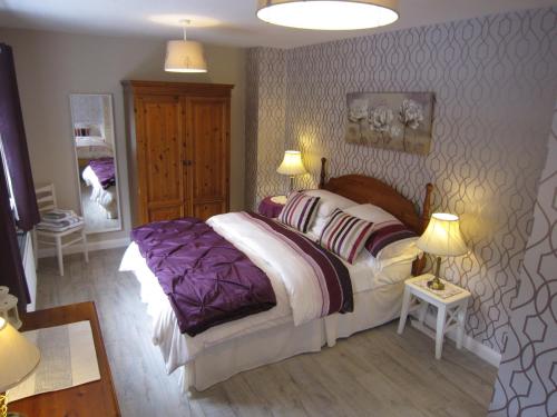 a bedroom with a large bed and two lamps at The Lookout, Glenarm in Glenarm