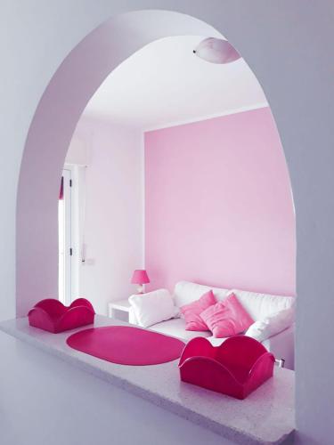 a white bedroom with a large bed with red pillows at Villa Milena Apartments & Rooms in Agropoli