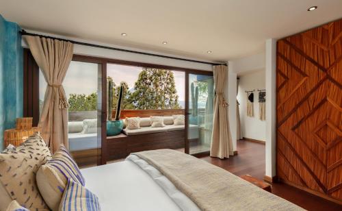 a bedroom with a bed and a large window at Hotel Casa Palopo in Santa Catarina Palopó