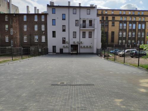 an empty parking lot with a building in the background at H33 Apartamenty in Bytom