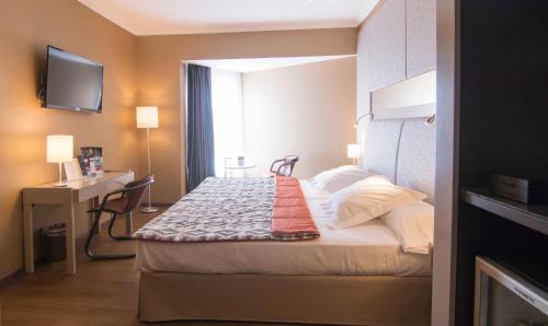 a small hotel room with a bed and a desk at Mercure Monte Igueldo in Donostia-San Sebastián